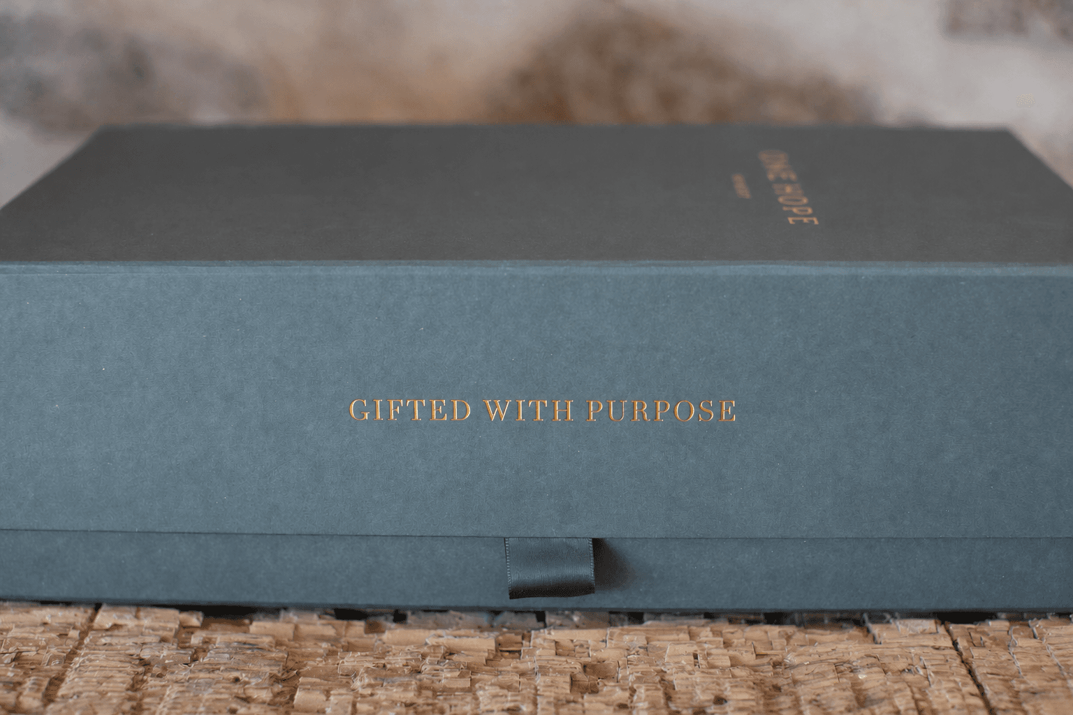 Dark green ONEHOPE gift box stamped Gifted with Purpose